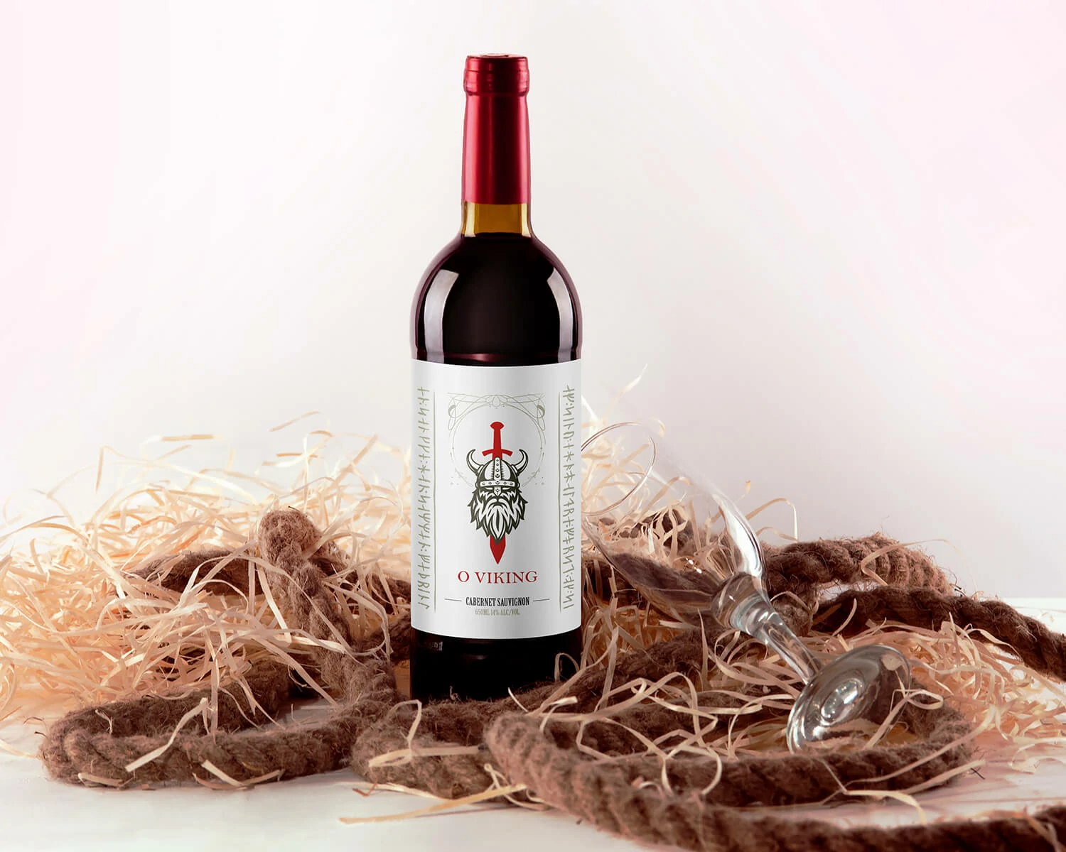 O Viking wine bottle in a lifestyle presentation with rope, straw and a wine glass